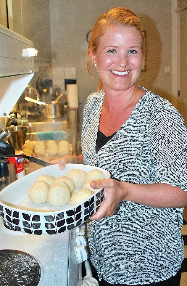 a woman holding a basket full of doughnuts