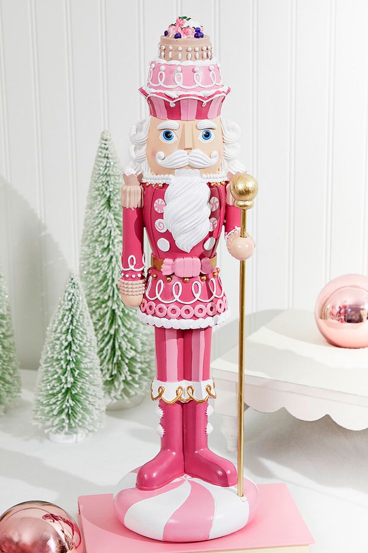 a nutcracker figurine is standing on a pink base