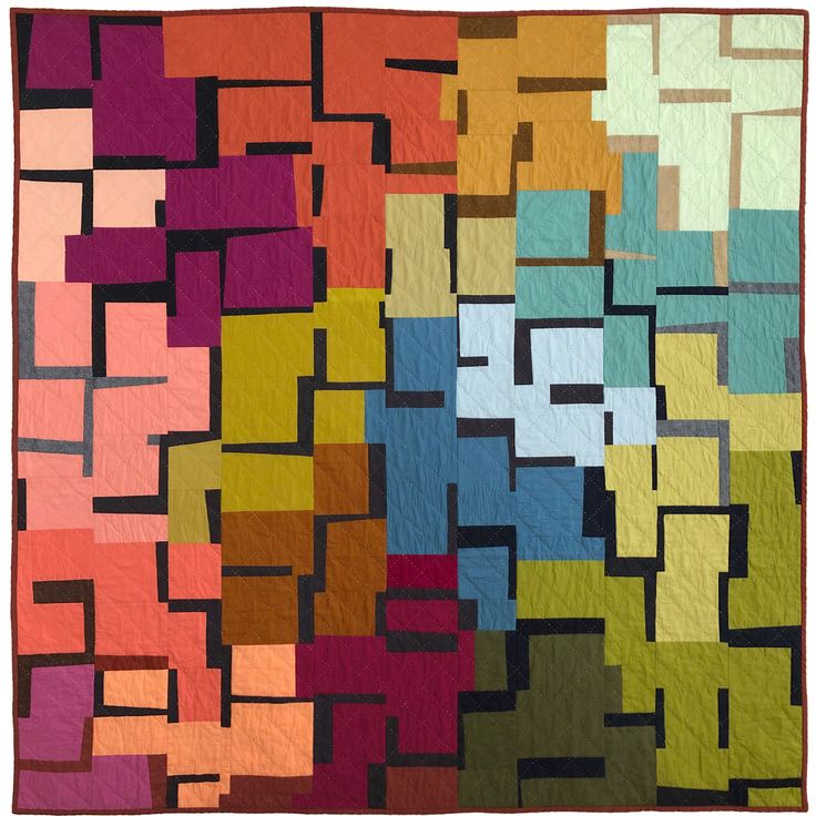 a colorful quilt is hanging on the wall