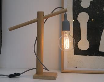 a light bulb sitting on top of a wooden table next to a framed photo and lamp