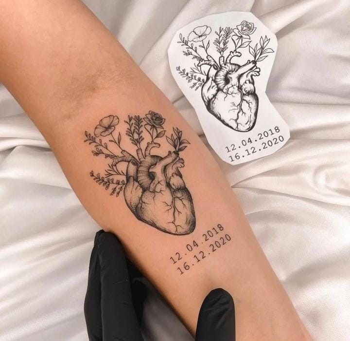 a heart tattoo on the arm with flowers