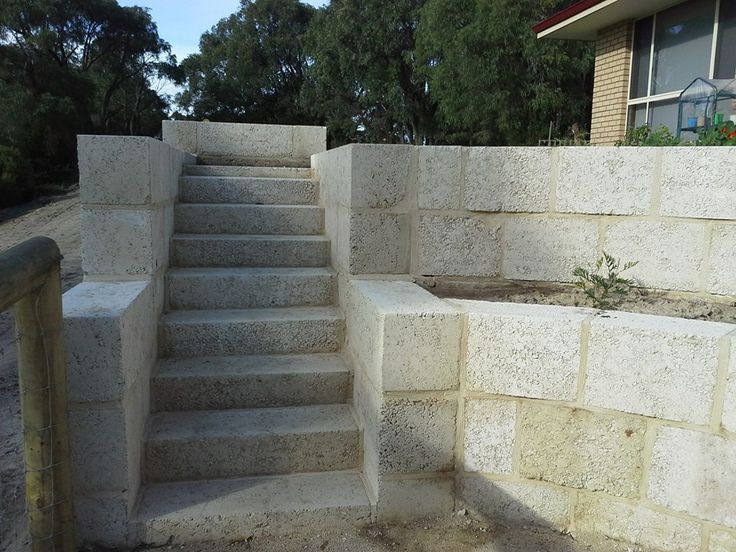 concrete steps leading up to a house with trees in the background