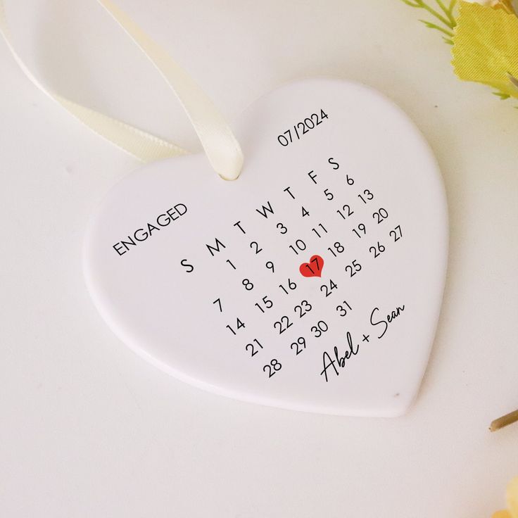 a white heart shaped ornament with a red heart on it