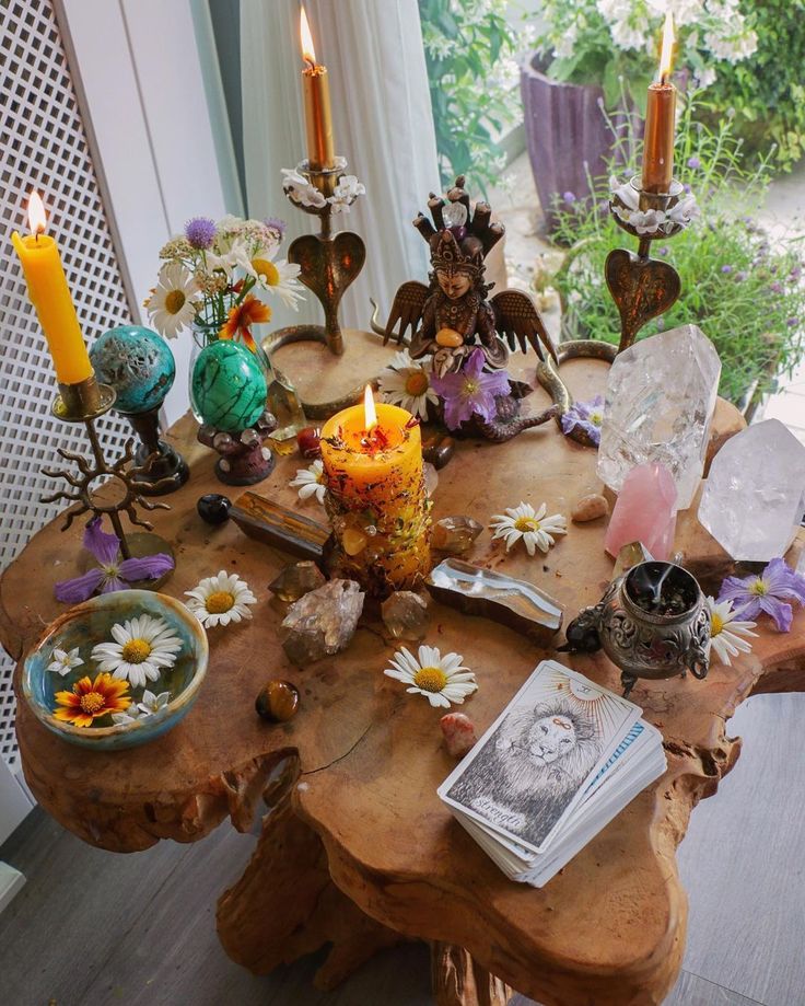 a wooden table topped with lots of different types of flowers and candles on top of it