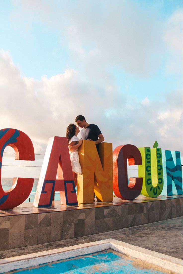 Couple standing in front of colorful Cancun sign in Cancun, Mexico Downtown Cancun, Ocean Spa, Cancun Photos, Mexico Bucket List, Cancun Resort, Cancun Tulum, Explore Mexico, Beach Shoot, Cancun Mexico