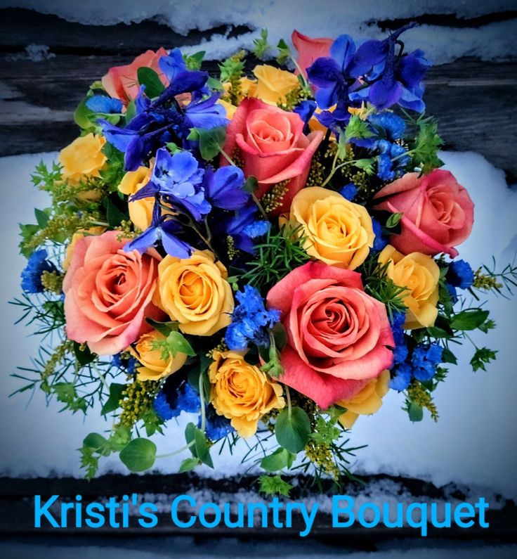 a bouquet of colorful flowers sitting on top of snow covered ground with the words krist's country bouquet