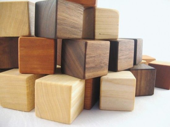 a pile of wooden blocks sitting next to each other on a white tableclothed surface