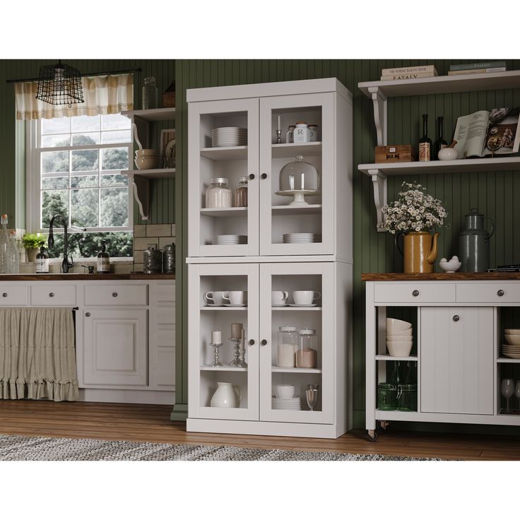 a kitchen with green walls and white cupboards in the center, along with an area rug on the floor