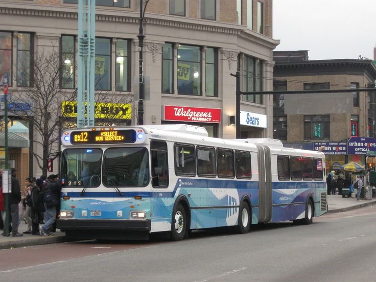 a blue and white bus is parked on the side of the road in front of some buildings