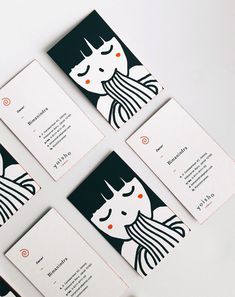 four business cards with black and white designs on the front, one has an image of a woman's face