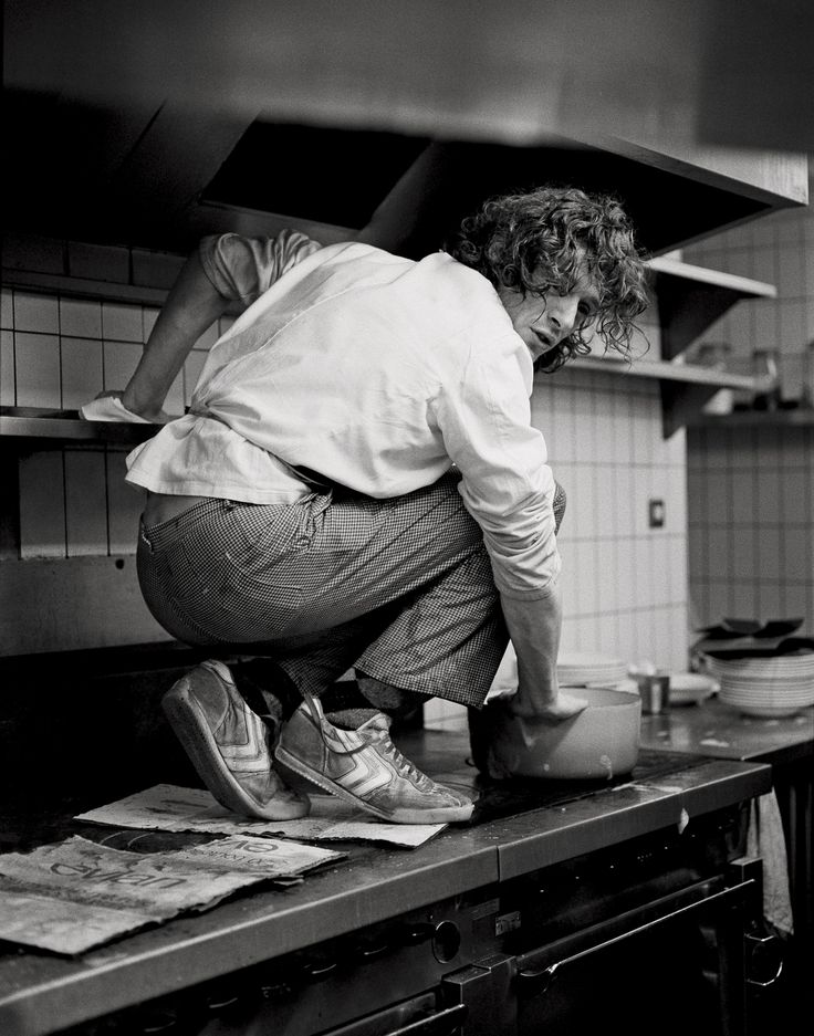 a woman bending over in the kitchen preparing food