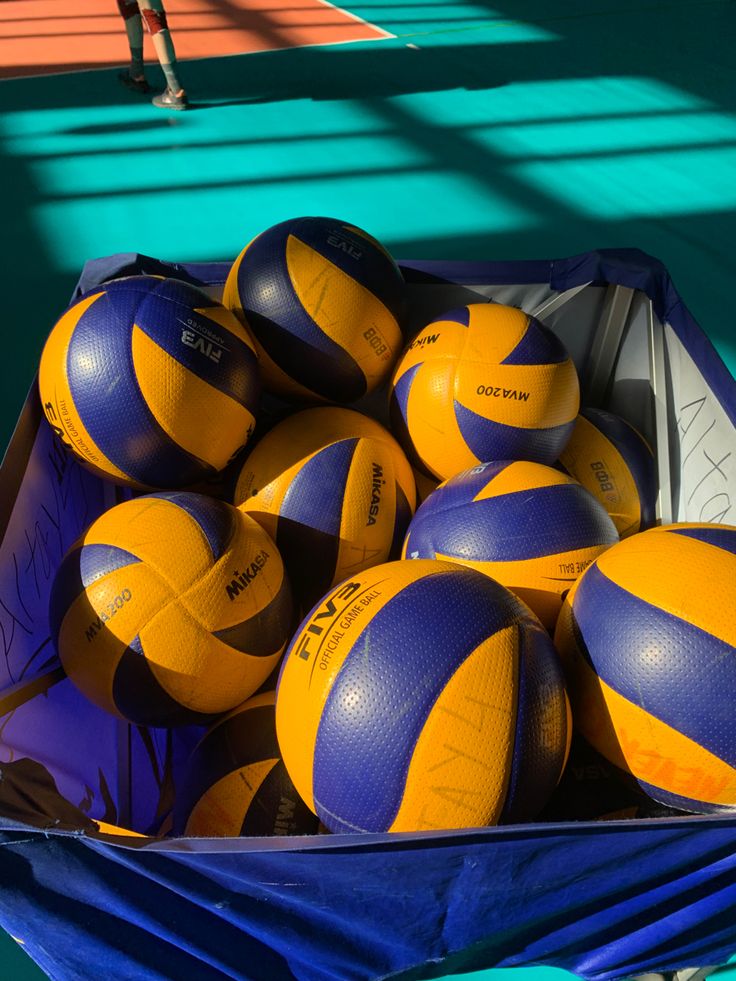 a box full of yellow and blue volleyballs