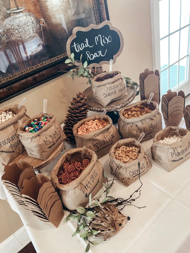 a table topped with lots of bags filled with food next to a chalkboard sign