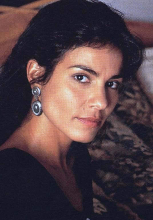 a close up of a person wearing earring's and looking at the camera