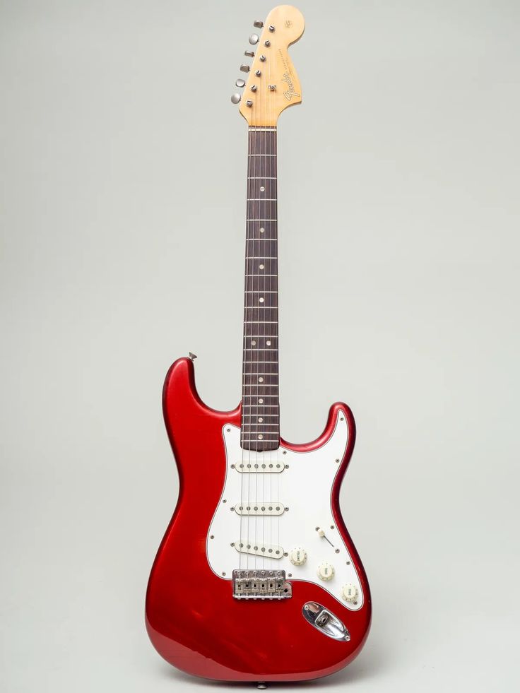 a red electric guitar sitting on top of a table