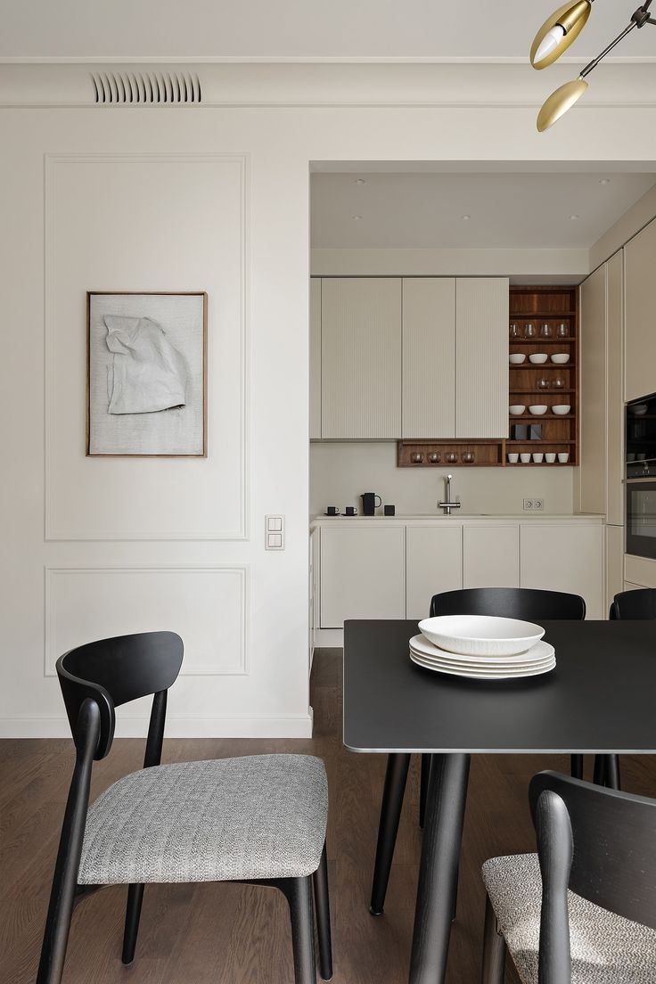 a black table and chairs in a small room with white walls on the other side