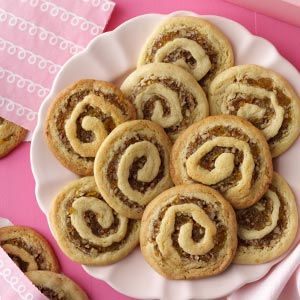 a plate filled with cinnamon rolls on top of a pink table