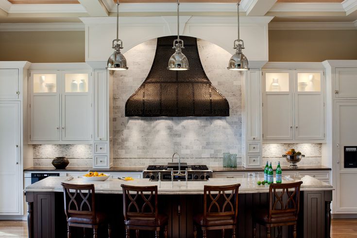 a large kitchen with an island in the middle and two chairs at the counter top