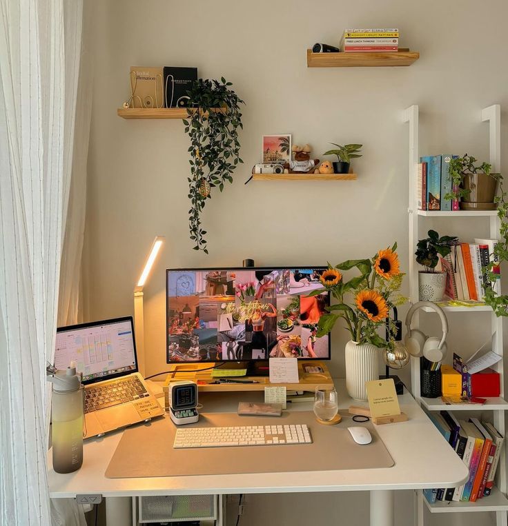 a desk with a computer, keyboard and monitor on it in front of a window