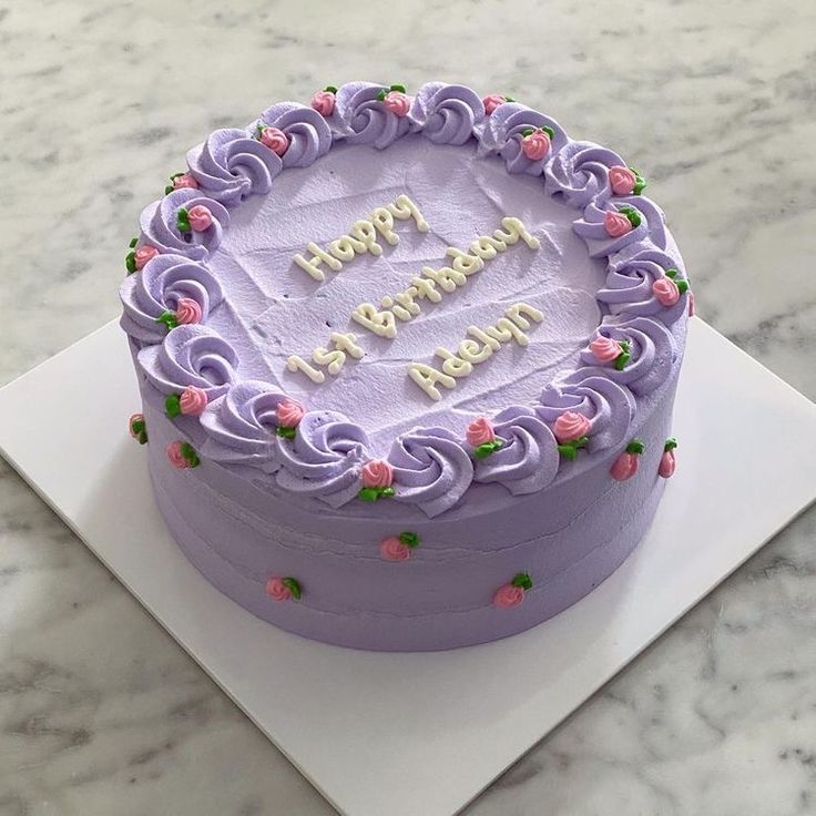 a purple birthday cake on a white plate