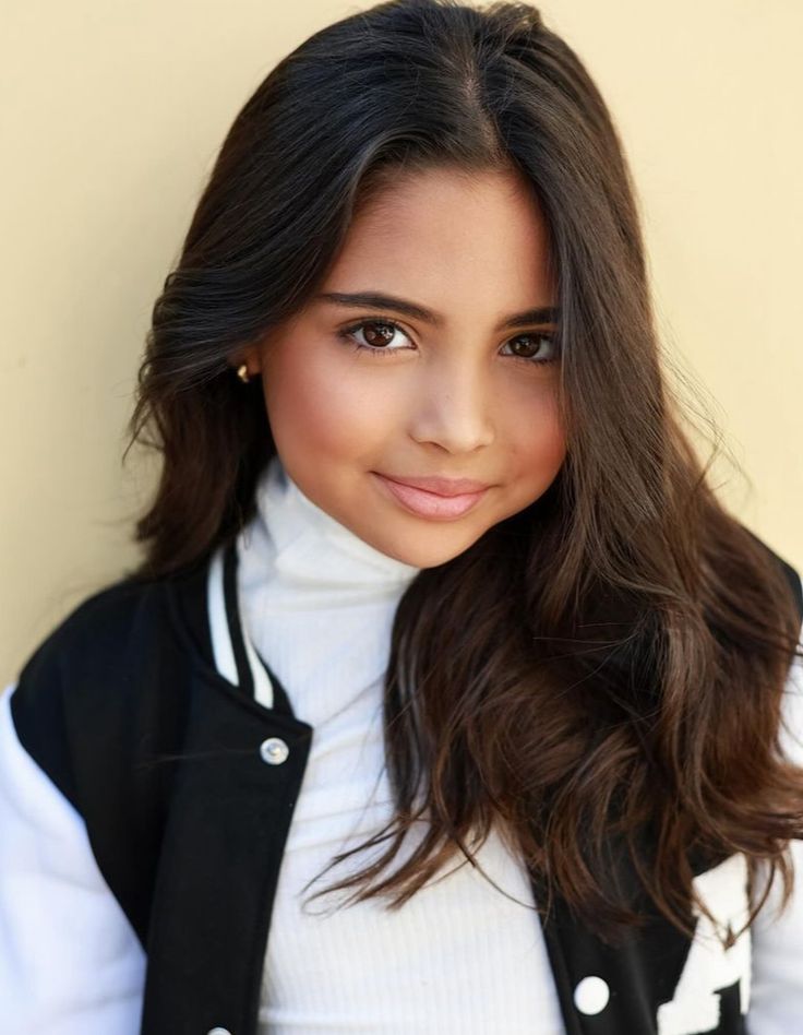 a woman with long hair wearing a black and white jacket