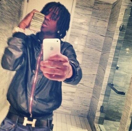 a man taking a selfie in the bathroom with his cell phone and stack of money