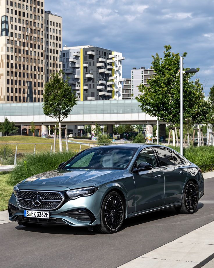 the mercedes cla is parked on the side of the road in front of tall buildings