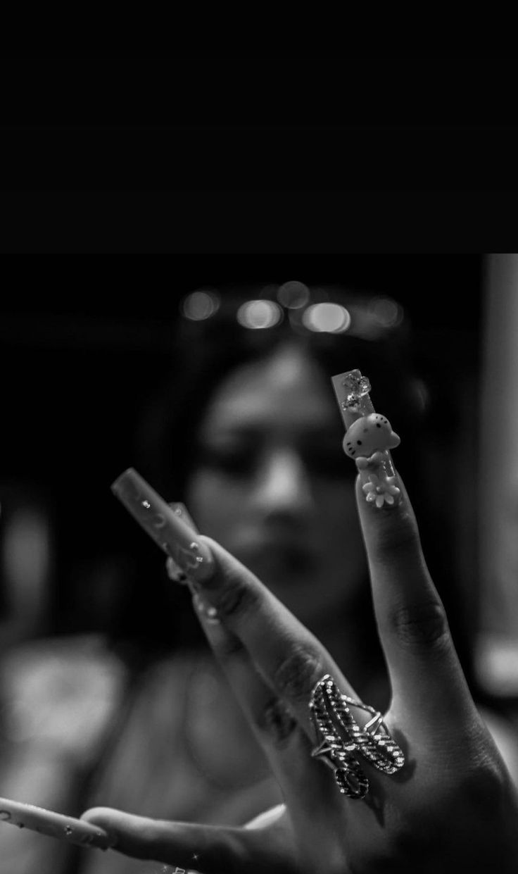 black and white photograph of a woman holding up her hand with two fingers in the air