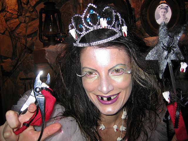 a woman wearing a tiara and holding a doll in front of two other dolls