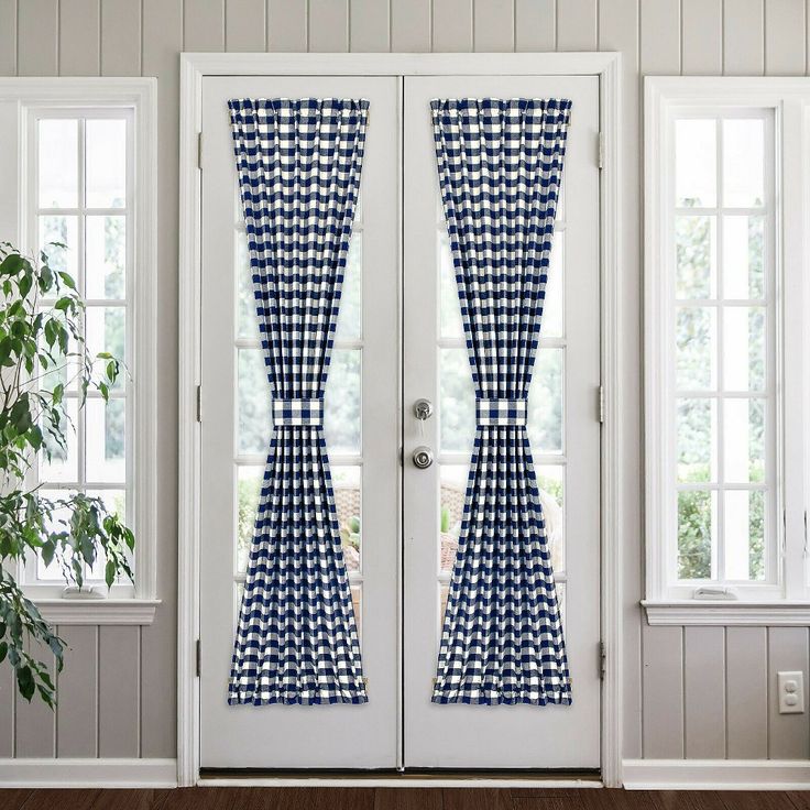 two blue and white checkered curtains hanging on the front door