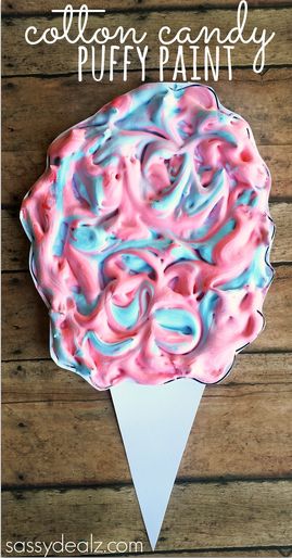 a cake with pink and blue icing on it sitting on top of a wooden table