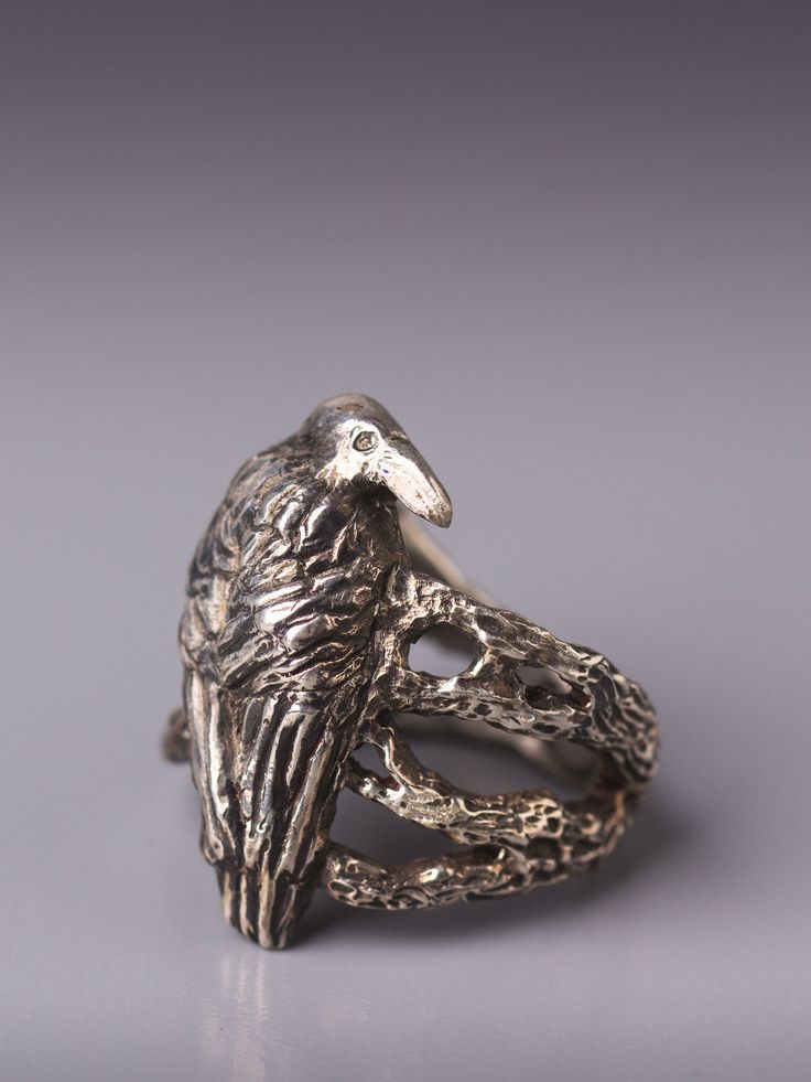 "Crow in the woodland silver ring. Crow as a totem animal is the keeper of sacred law, can see beyond illusion of the physical world and can \"shape shift\". As a guide crow teaches personal integrity, to speak your truth, walk your talk and be truthful to yourself. In creating this ring I was inspired by the mysterious nature of crow that seem to know more than what is on the surface. In the design of the ring I placed the crow on tree twigs and branches, inspecting and watching. Even though th Unique Collectible Ring Jewelry, Symbolic Adjustable Ring With Unique Design, Unique Hand Cast Engraved Promise Ring, Spiritual Hand Cast Promise Rings, Unique Skull Ring For Anniversary, Unique Hand Cast Round Rings, Nature-inspired Brass Jewelry For Anniversary, Nature-inspired Jewelry With Unique Design For Gift, Spiritual Ring With Unique Design