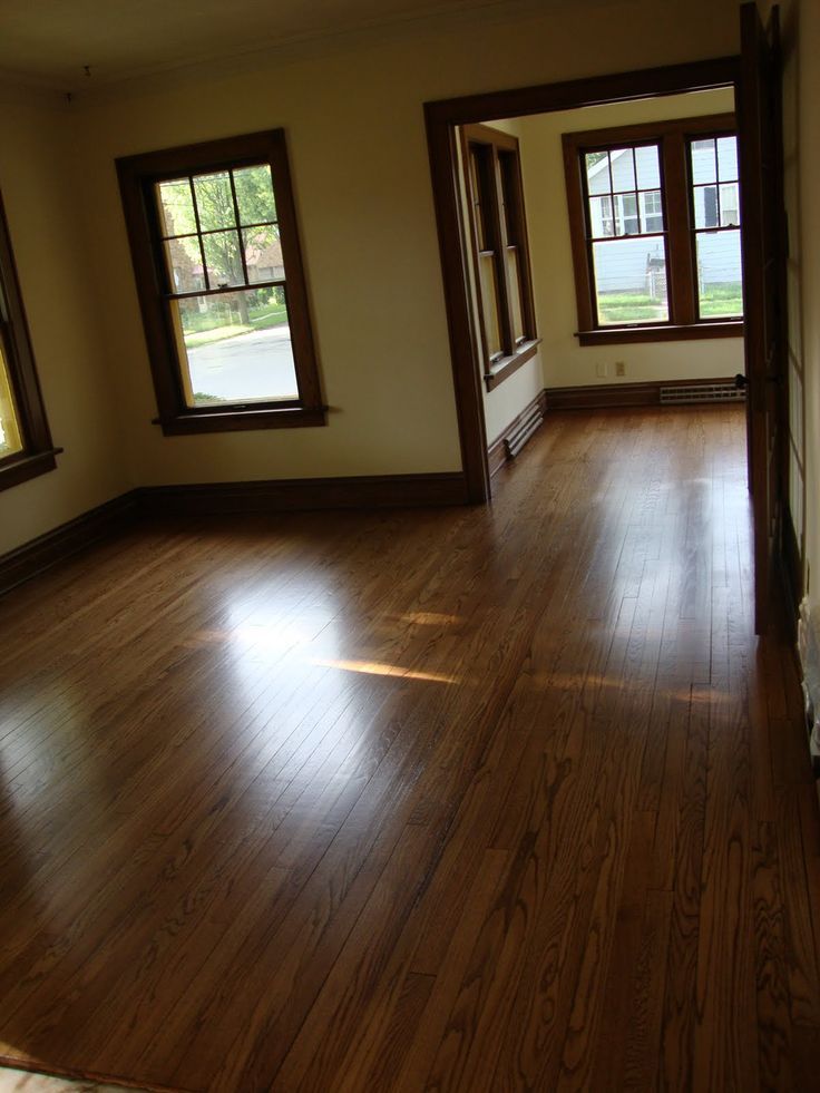 an empty room with wood floors and windows