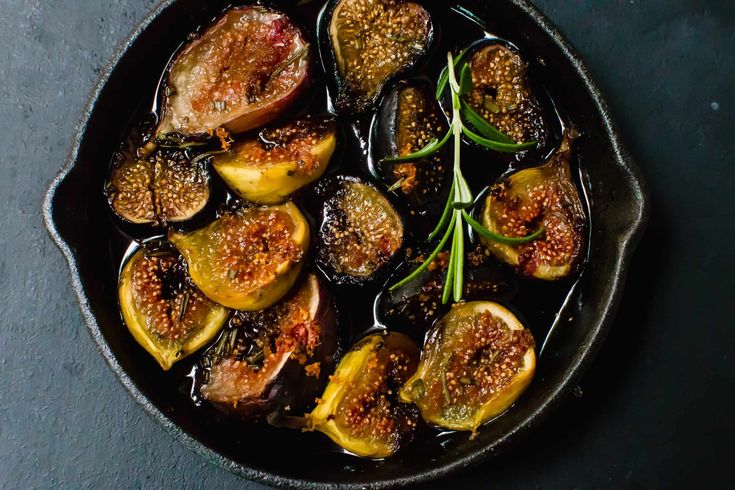 figs are cooked in a cast iron skillet and garnished with rosemary