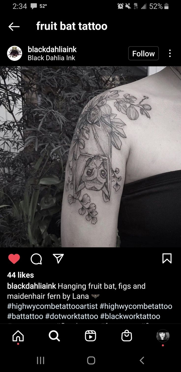 the back of a woman's shoulder with flowers and leaves on it, in black and white