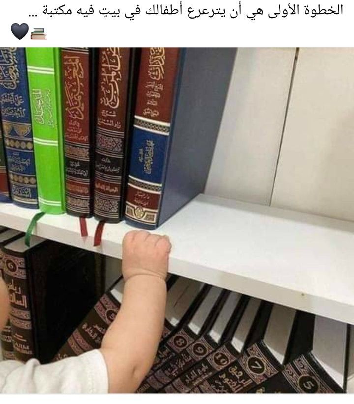 a small child reaching for books on a shelf in a book store with arabic writing