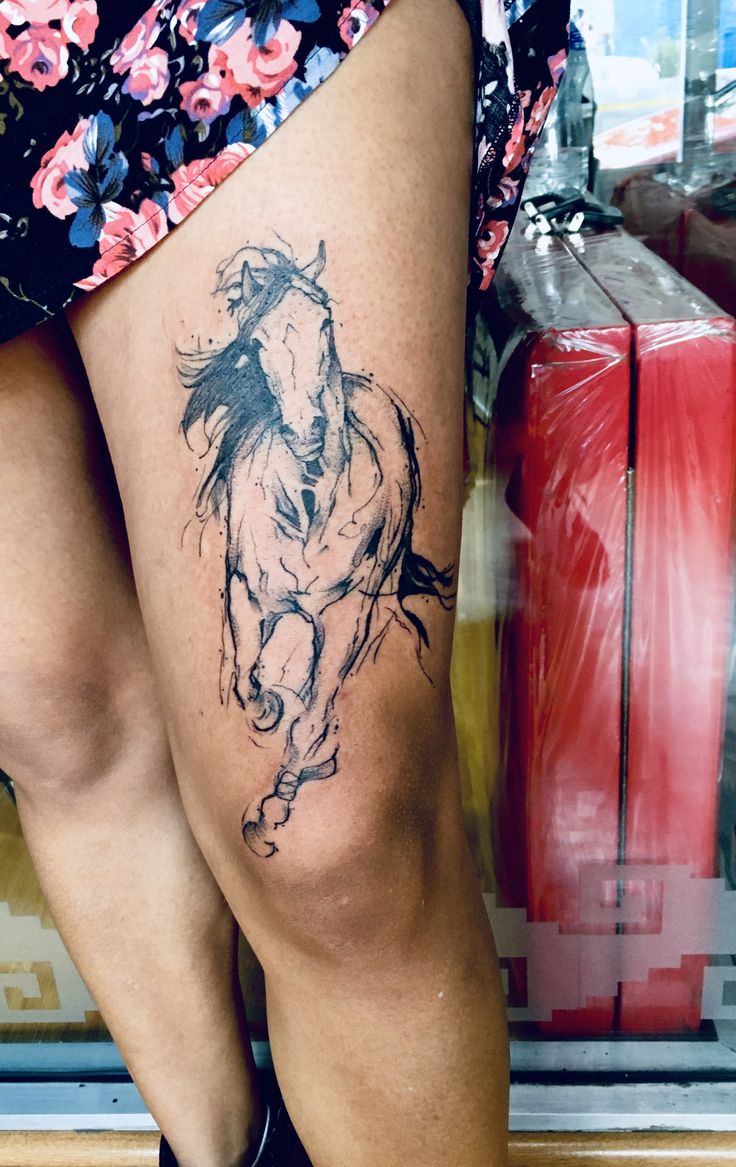 a woman's leg with a horse tattoo on it and her legs are shown