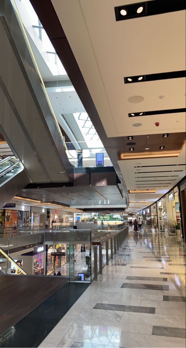 an empty shopping mall with escalators and stairs