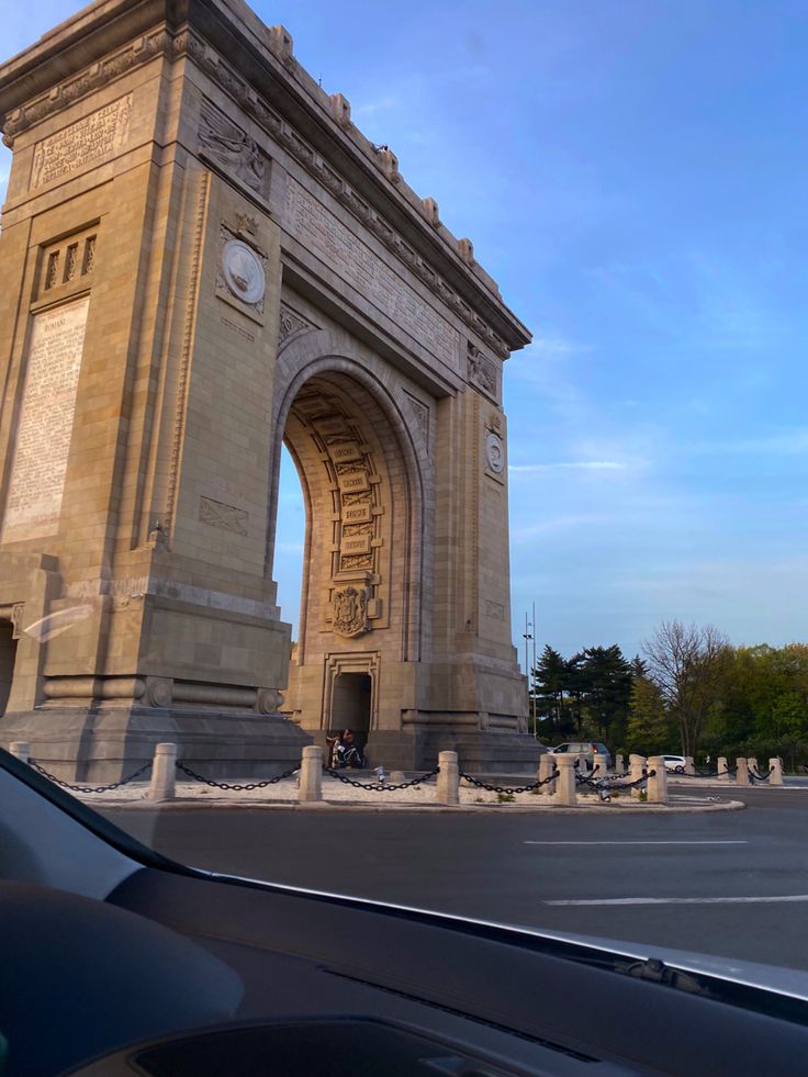 a car is parked in front of an arch