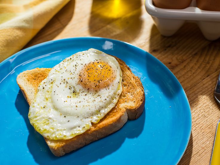 a blue plate topped with an egg on top of toast