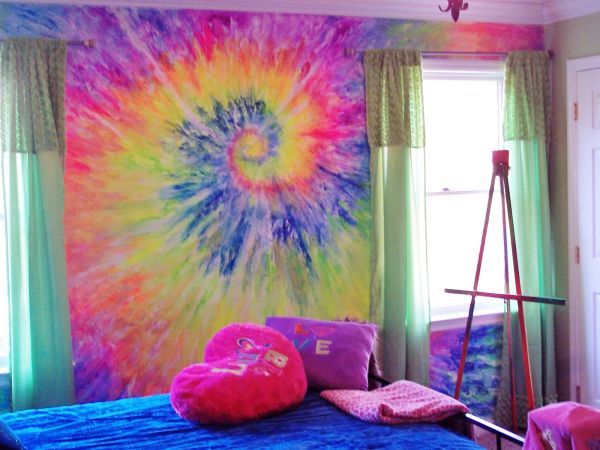 a bedroom decorated in tie - dyed colors with pink and blue pillows