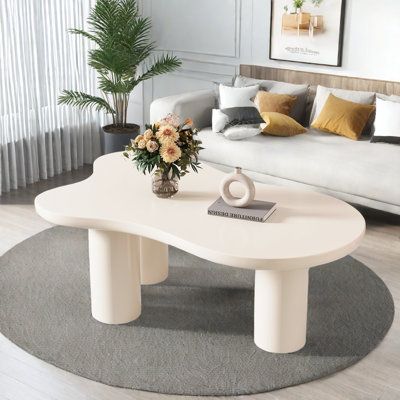 a white coffee table sitting on top of a rug in front of a living room