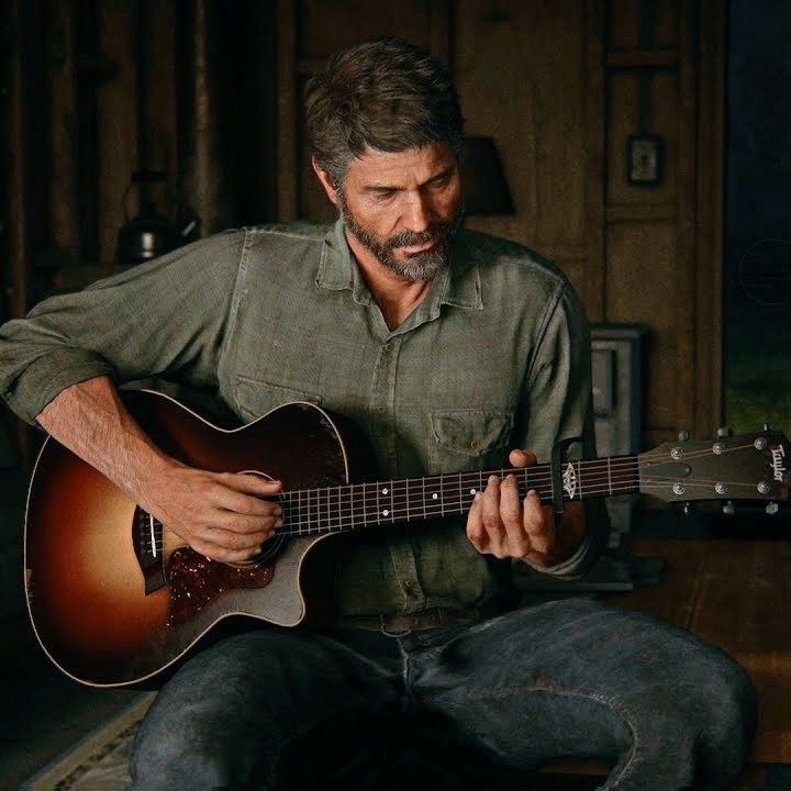 a man sitting on the floor playing an acoustic guitar