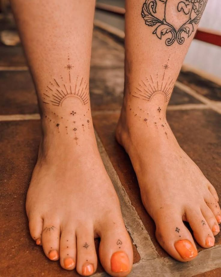 a woman's feet with sun and stars tattoo on her left foot, sitting on a tile floor