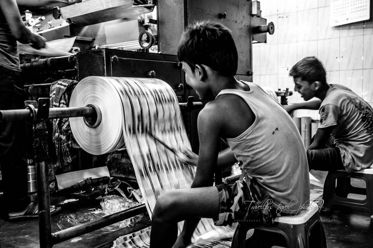 two boys working on a machine in a factory