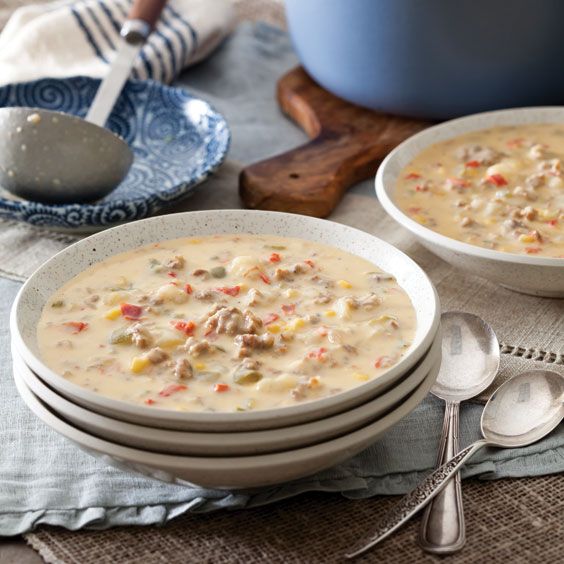 two bowls filled with soup on top of a table next to silverware and spoons