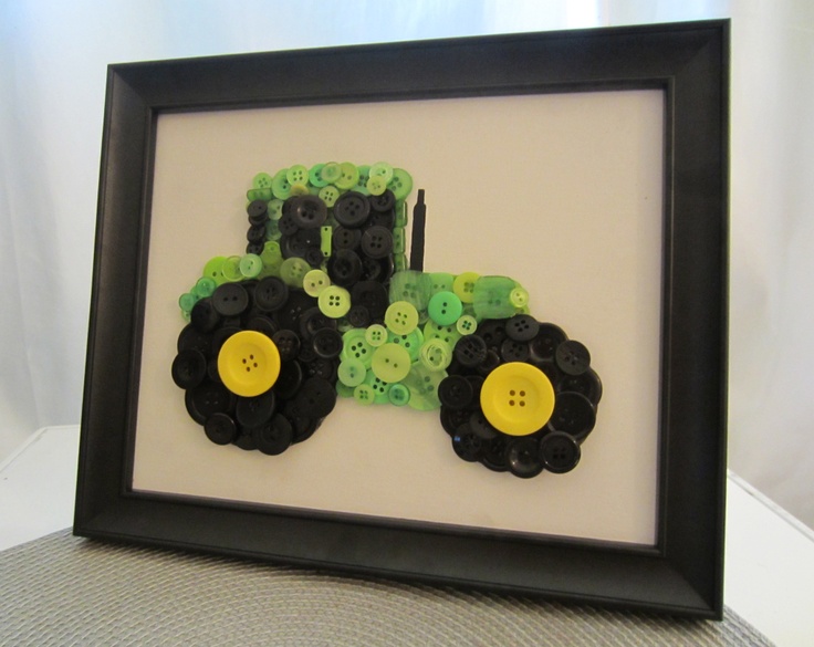 a black frame with a green and yellow tractor on it's side, sitting next to a white wall