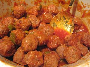 meatballs and peppers are being stirred with a spoon