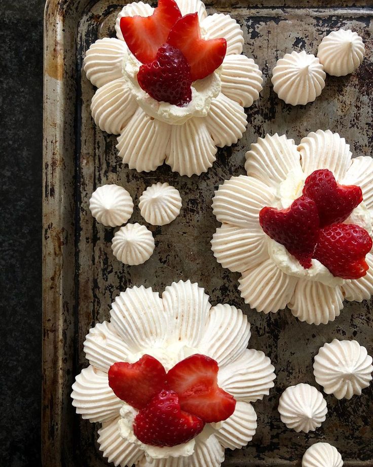 strawberries and whipped cream arranged on top of each other in heart - shaped cupcakes