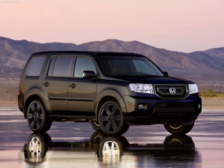 an suv is parked in the middle of a lake with mountains in the back ground